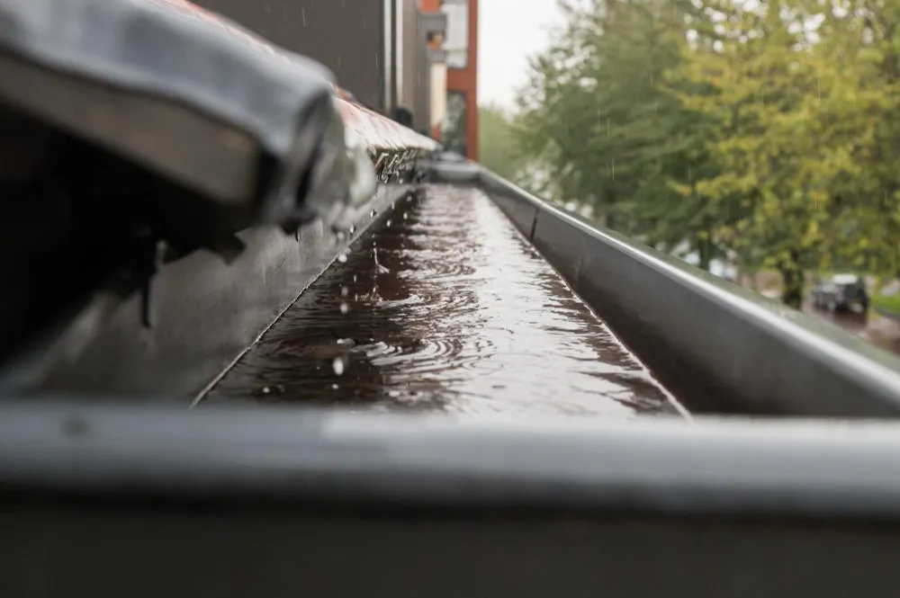 Das Regenwasser fließt vom Dach in das Ablaufrohr