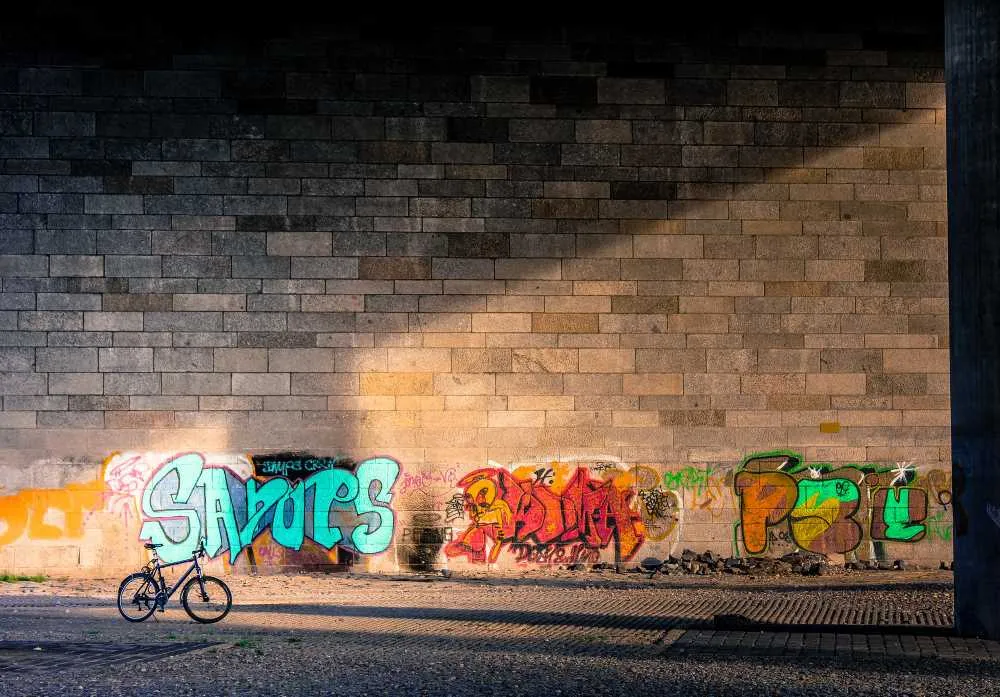 Fahrrad, das an eine Wand mit Graffitis gelehnt ist
